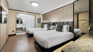 A hotel room with two beds, a bathroom with a mirror, and a large mirror on the wall. - Hudson Yards Hotel (New York)