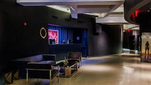 A modern lobby with a reception desk, seating area, and a curved wall structure. - Hudson Yards Hotel (New York)