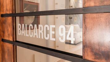 Porta di una camera d'albergo con una targa che riporta la scritta "BALCARCE 94".
