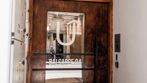 A wooden door with a glass panel and a large white letter 'U' on it. - RentUp Suites Salta (Salta)