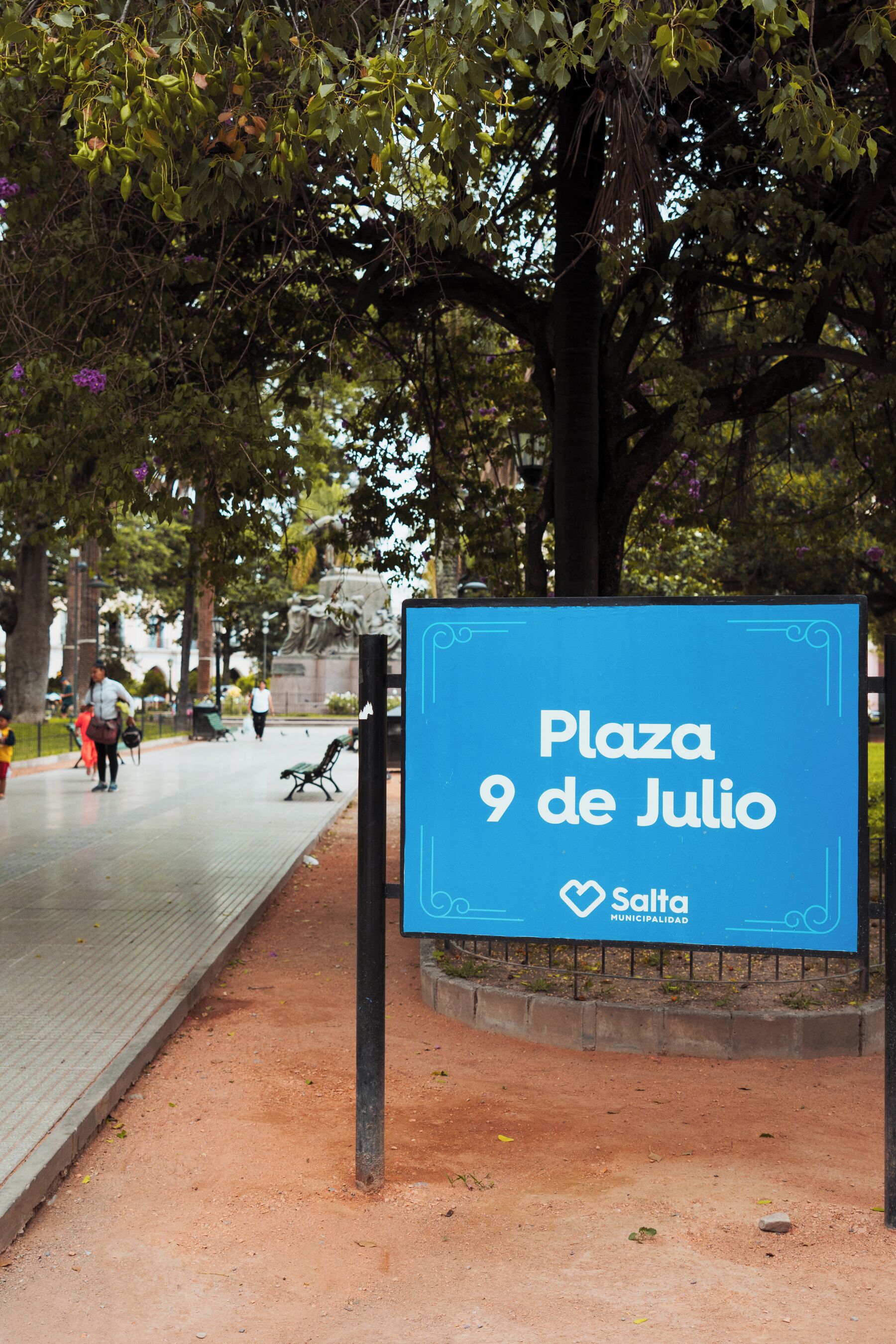 Un panneau indiquant la place du 9 de Julio, offrant une vue dégagée sur le parc environnant.