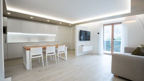 A modern apartment with a kitchen, dining area, and living room.