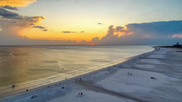 A wide beach with a sunset in the background. - Palm Bay Club Private Balcony Beach Side  (Sarasota)