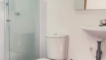 Eenvoudige tweepersoonskamer | Badkamer | Een douche, handdoeken, zeep, toiletpapier