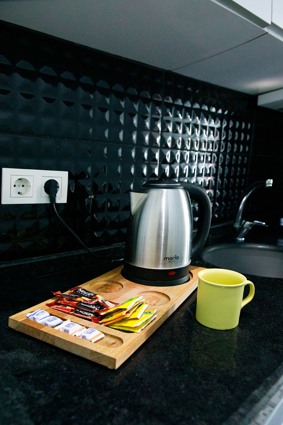 A kitchen counter with a coffee maker, a mug, and a cutting board with food items.