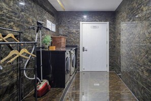 A hotel room with a marble floor, a door, a laundry area with a washing machine, and a towel rack. - H Hotel (Xi'an Bell and Drum Tower Nanmenwai Northwest University Shuijing) (Xi'an)
