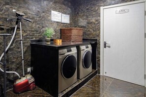 A laundry area with a washing machine, dryer, and a vacuum cleaner. - H Hotel (Xi'an Bell and Drum Tower Nanmenwai Northwest University Shuijing) (Xi'an)
