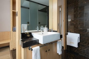 A modern bathroom with a large mirror, a white sink, and a black countertop. There are towels hanging on a rack and a wooden cabinet. - H Hotel (Xi'an Bell and Drum Tower Nanmenwai Northwest University Shuijing) (Xi'an)