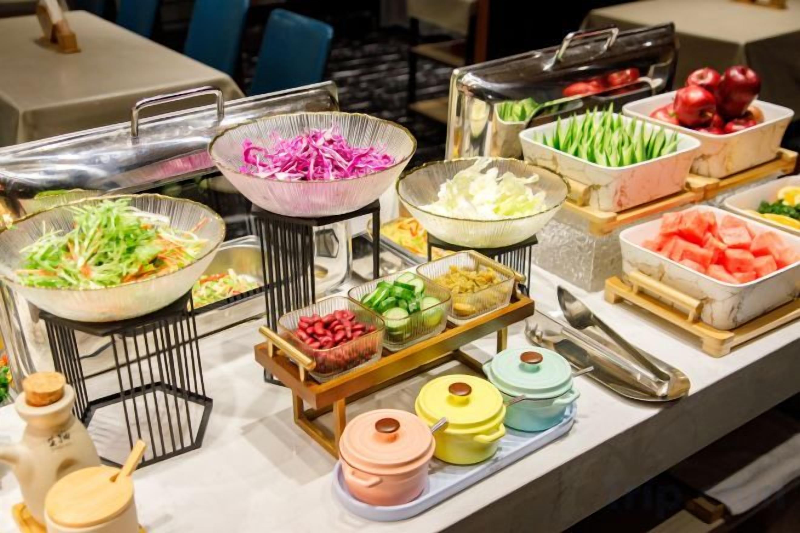 Una mesa de buffet con diversos alimentos y salsas.