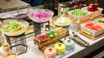 Una mesa de buffet con diversos alimentos y salsas.
