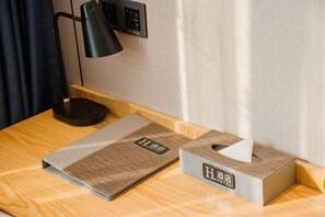 A hotel room with a wooden nightstand, a black desk lamp, a tissue box, and a menu or information booklet. - H Hotel (Xi'an Bell and Drum Tower Nanmenwai Northwest University Shuijing) (Xi'an)