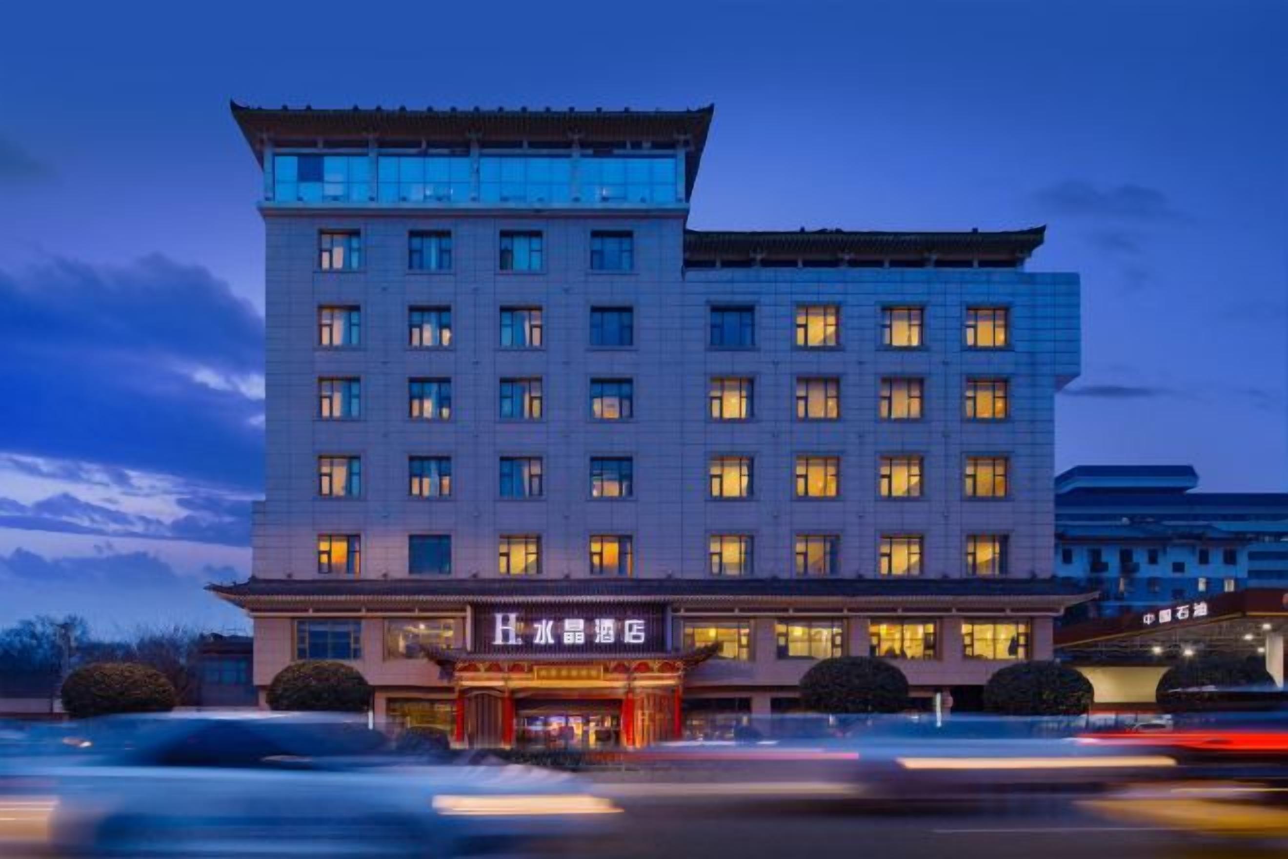 Un hôtel à plusieurs étages, de style architectural traditionnel, qui se distingue par son entrée imposante et ses nombreuses fenêtres.