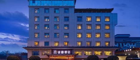 Un hôtel à plusieurs étages, de style architectural traditionnel, qui se distingue par son entrée imposante et ses nombreuses fenêtres.