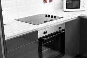 A kitchen with a built-in stovetop, oven, and microwave. - Two Bed Apartment - Smart TV - WIFI - Jewellery Quarter (Birmingham)
