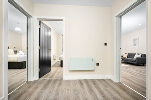 Un interior moderno con suelo de madera, un calentador de pared y un sofá en una sala de estar.