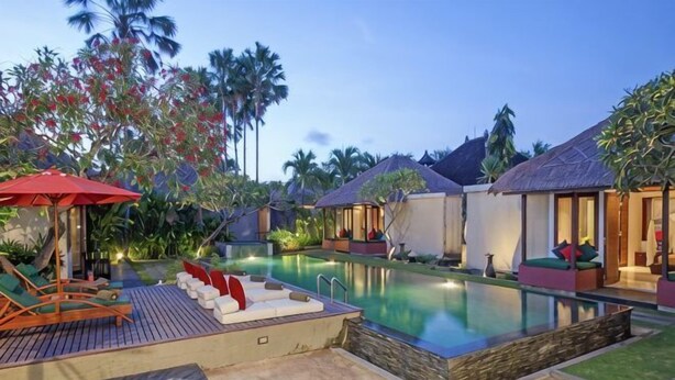 A resort with a swimming pool, lounge chairs, and overwater bungalows. - Imani Villas Bali (Bali)