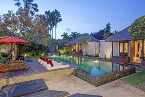 A resort with a swimming pool, lounge chairs, and overwater bungalows. - Imani Villas Bali (Bali)