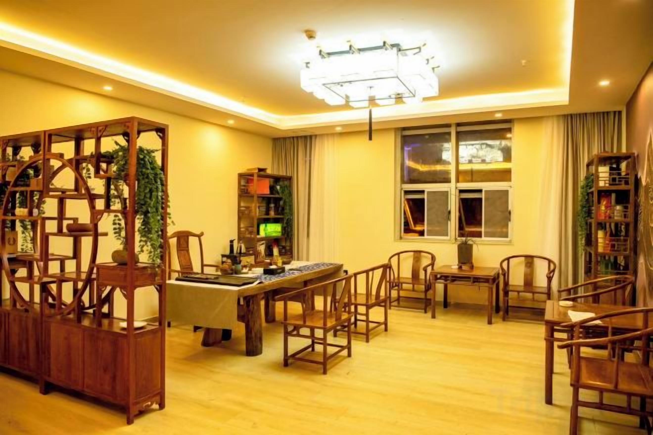 Una habitación bien iluminada con una mesa de comedor, sillas, una estantería y un ventanal grande.