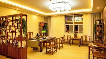 Una habitación bien iluminada con una mesa de comedor, sillas, una estantería y un ventanal grande.