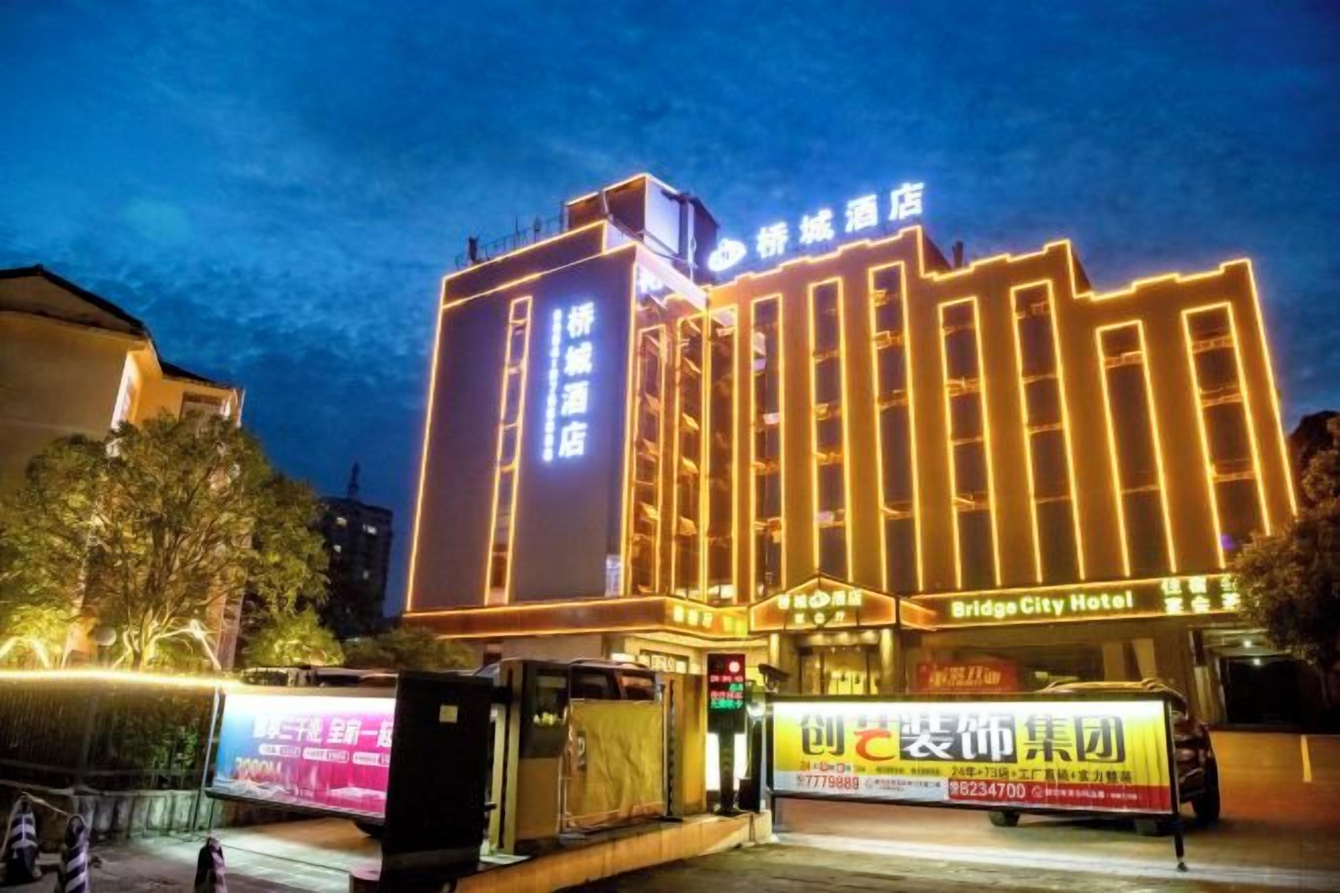 A hotel with a prominent sign, multiple floors, and a well-lit facade.
