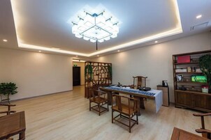 Un comedor con una mesa y sillas, una lámpara decorativa en el techo y una estantería.