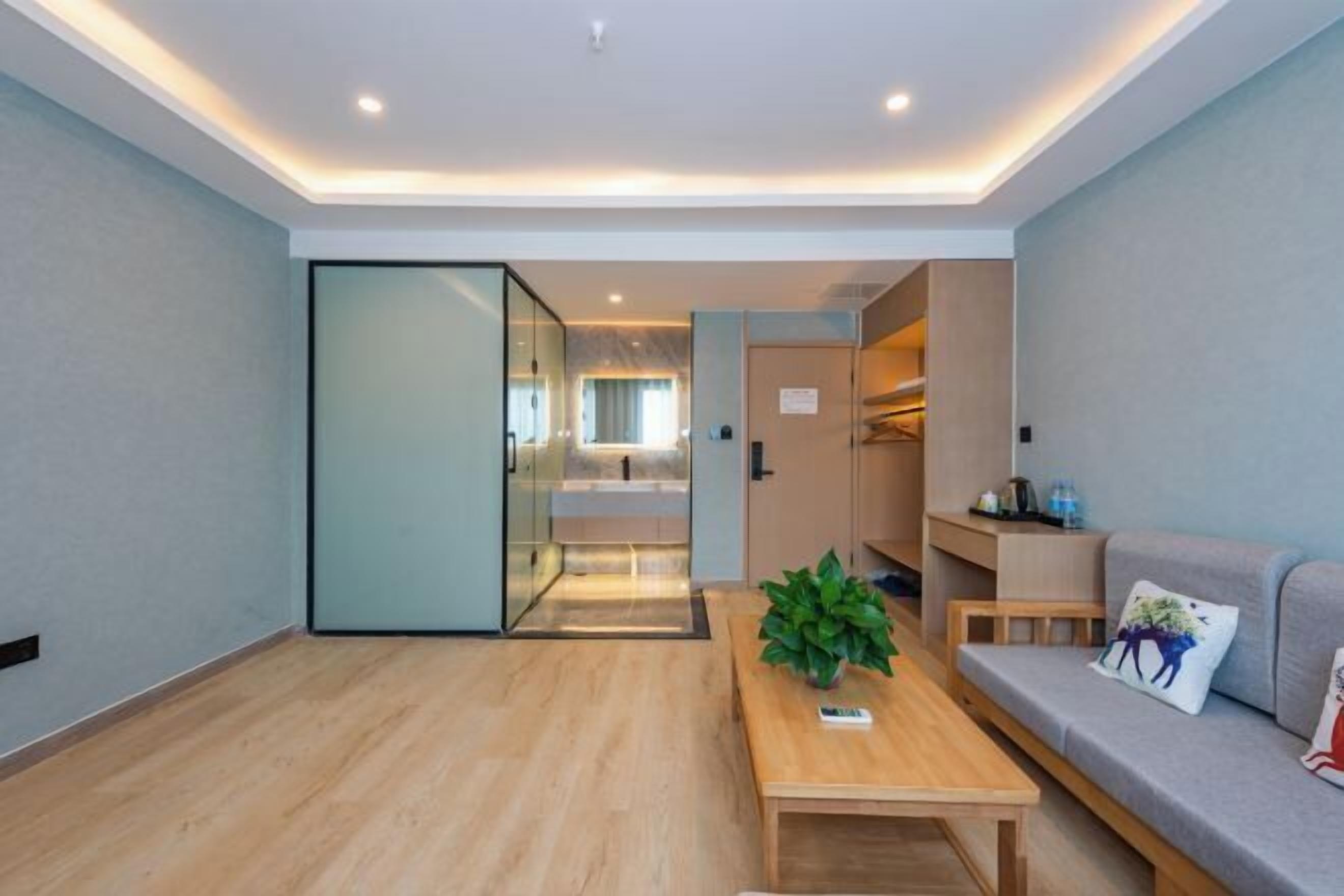 Una sala de estar moderna con una mesa de centro de madera, un sofá y un separador de vidrio.