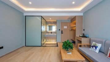 Una sala de estar moderna con una mesa de centro de madera, un sofá y un separador de vidrio.