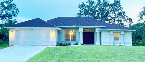 A two-story house with a garage, a front door, and a driveway.