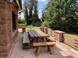 An outdoor patio with stone benches and a brick wall.