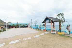 Una propiedad frente a la playa con un espacio de estar cubierto, una piscina y vista al mar.