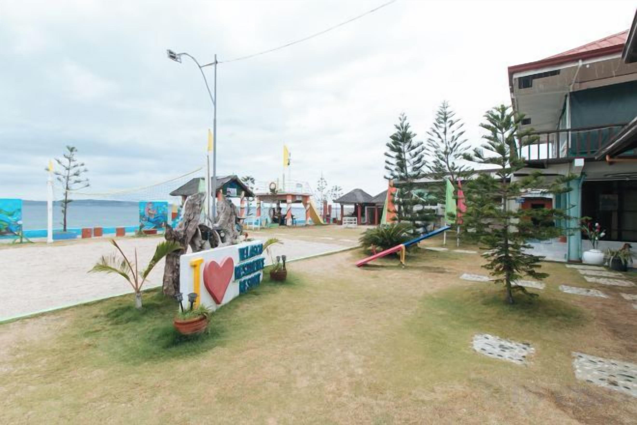 Una propiedad frente al mar con un cartel, un pequeño edificio y vistas al océano.