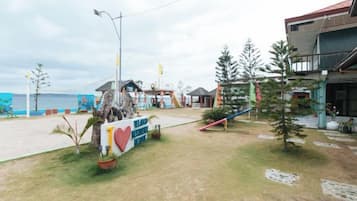 Una propiedad frente al mar con un cartel, un pequeño edificio y vistas al océano.
