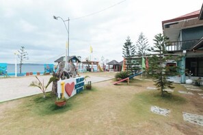 Une propriété située en bord de mer, avec un panneau indicateur, un petit bâtiment et une vue sur la mer.