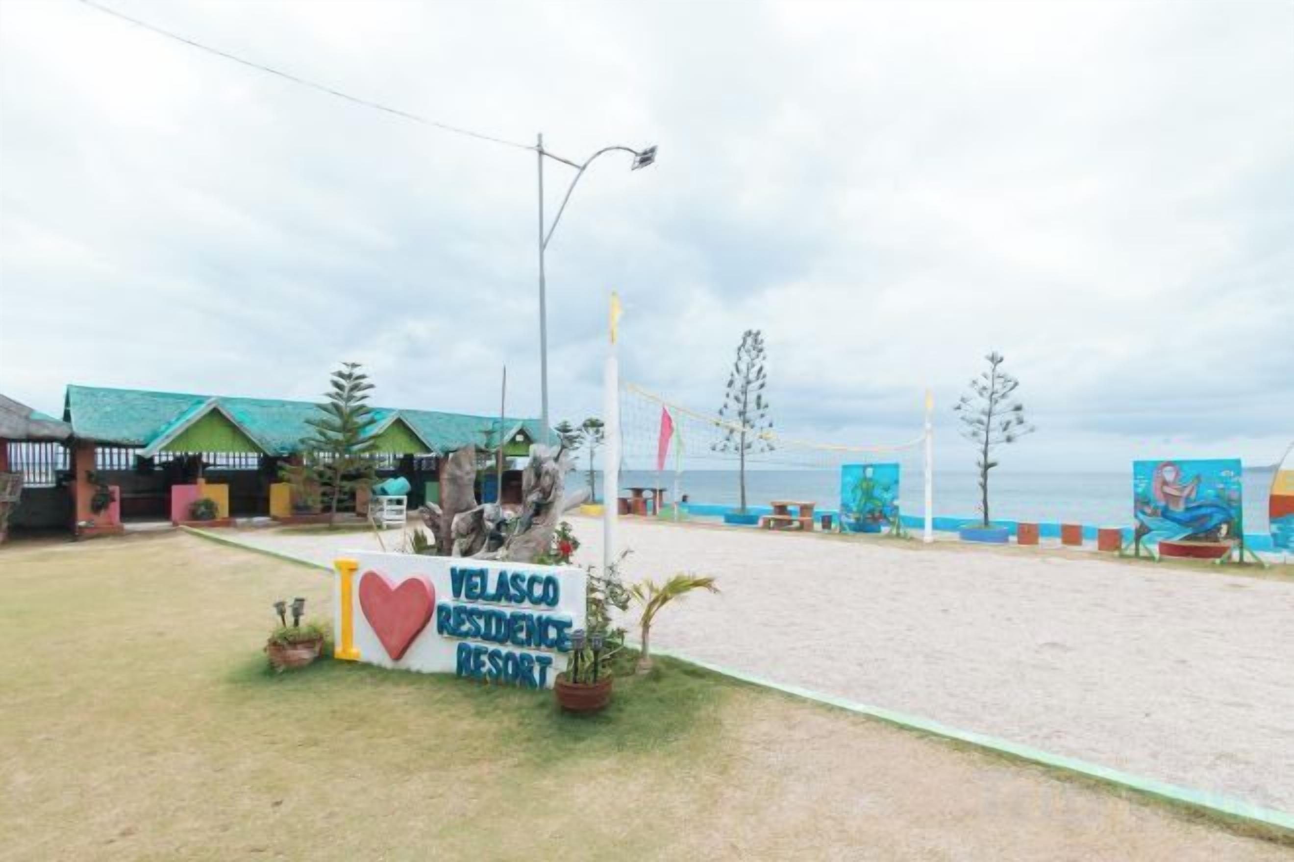 Strandresort mit Schild, Strand und Wandgemälde.