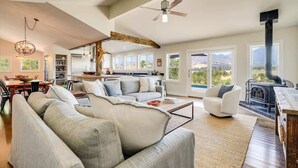 A spacious living area with a large sofa, a dining table, and a kitchen in the background. - Calistoga Vista-Pool, Hot Tub - Tastings Included (Calistoga)