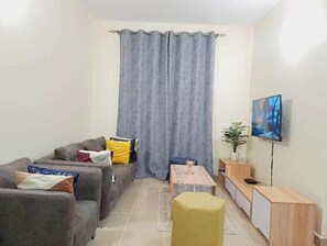 Cozy living space with a sofa, table, and television, perfect for relaxing.