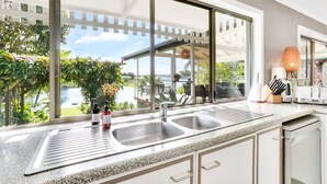 A modern kitchen with a large window, a built-in sink, and a dish drying rack.