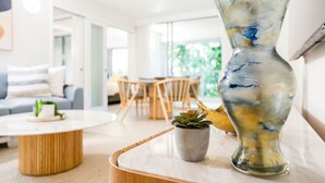 A modern living room with a round coffee table, a potted plant, and a decorative vase.