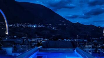 Una piscina al aire libre, sillones reclinables de piscina
