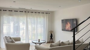 Un salon moderne avec deux canapés, une petite table ronde et un escalier.