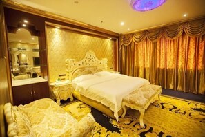 A luxurious hotel room with a large bed, a vanity with a mirror, and a plush sofa.