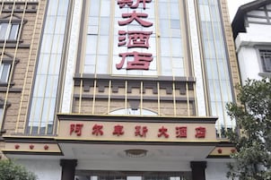A hotel with a prominent sign featuring Chinese characters and a smaller sign below it.