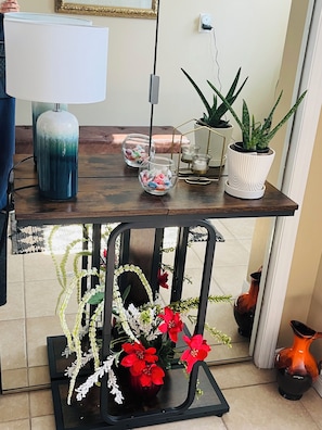 A dining table with a lamp, glass containers, and potted plants.