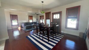 A spacious living area with a dining table, chairs, and a sofa.