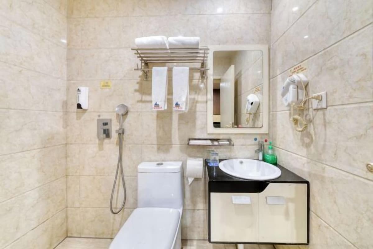 Un baño moderno con inodoro, bidé, lavamanos y perchero para toallas.