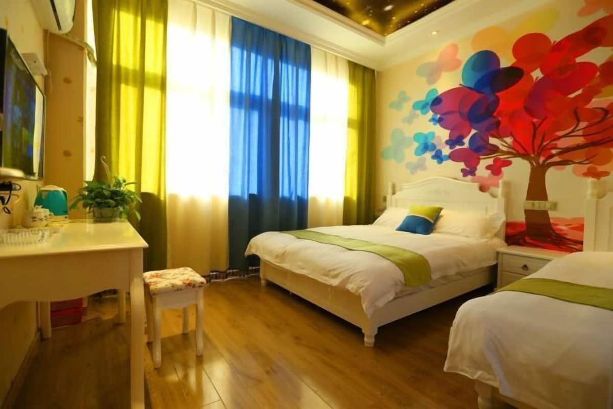 A bedroom with a bed, bedside tables, a desk, and a chair.