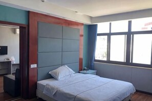 A hotel room with a bed, a nightstand, a desk, and a window with a view. - Hua Yang Hotel (Yuhuan)