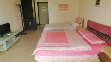 A bedroom with a bed, a TV, a wardrobe, and a door.