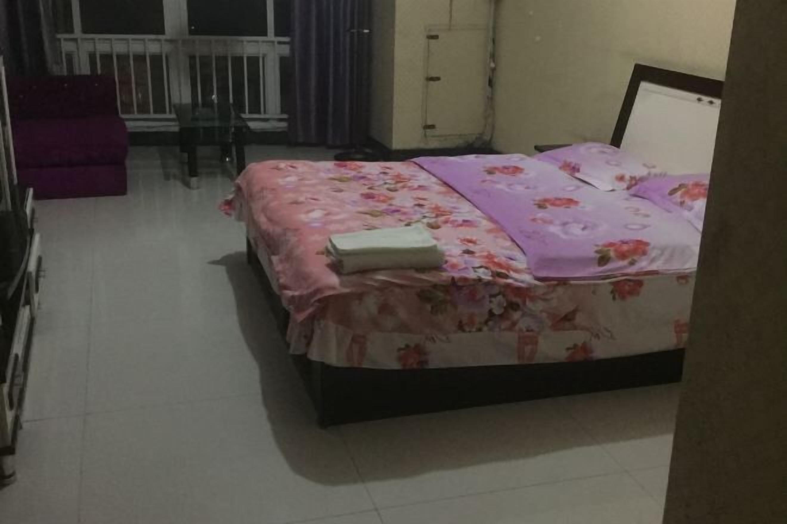 Una camera da letto con un letto, una sedia e un divano viola.