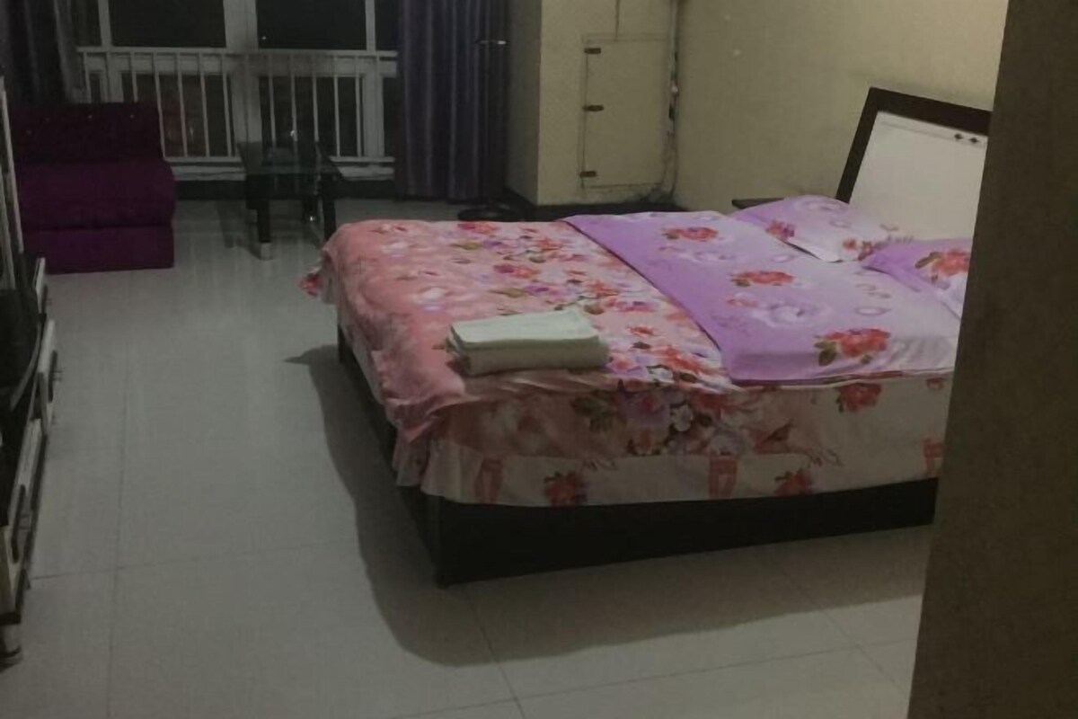 Quarto com cama, cadeira e sofá roxo.